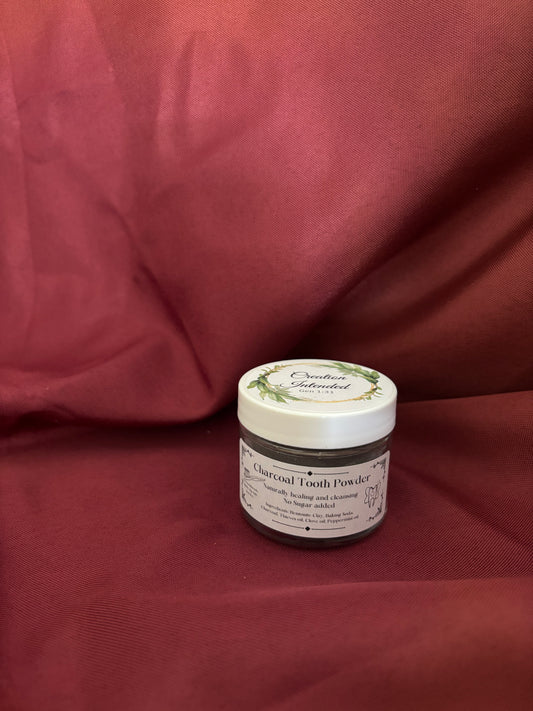 Jar of charcoal tooth powder on a red fabric background